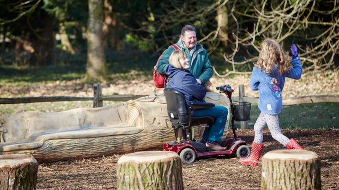 Grandparents and a grandchild play together in the Log Stack play area in Dyffryn Gardens during the winter